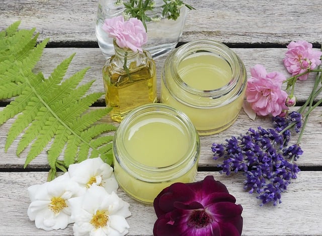luonnonkosmetiikka purkeissa pöydällä ja kukkia